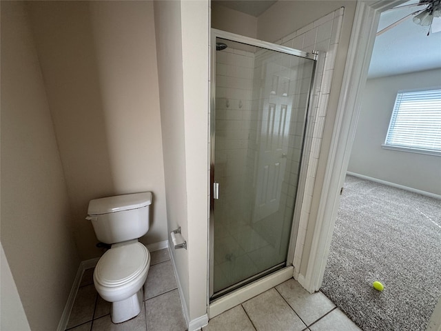 bathroom featuring tile patterned floors, toilet, and a shower with shower door