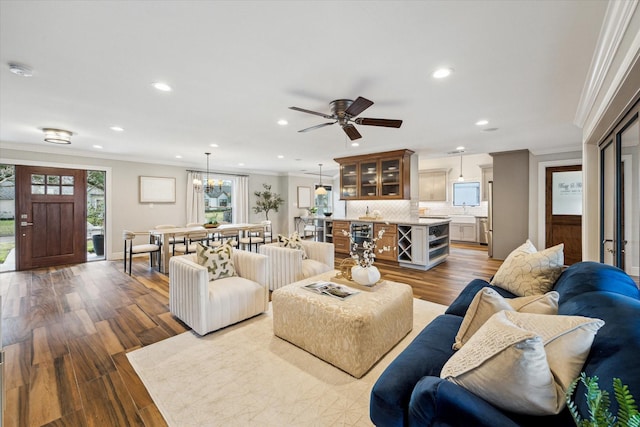 living room with crown molding, ceiling fan, and light wood-type flooring