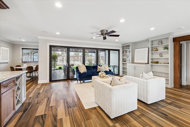 living room with hardwood / wood-style floors, ornamental molding, and ceiling fan