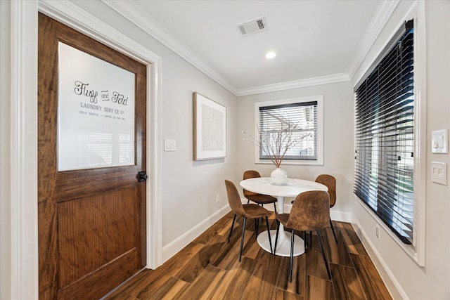 dining space with ornamental molding and dark hardwood / wood-style floors