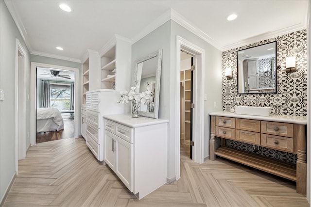 interior space featuring white cabinetry, sink, crown molding, and light parquet flooring