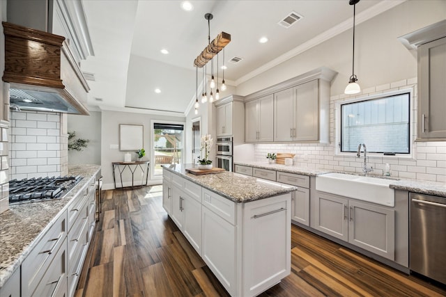 kitchen featuring crown molding, sink, decorative light fixtures, and appliances with stainless steel finishes