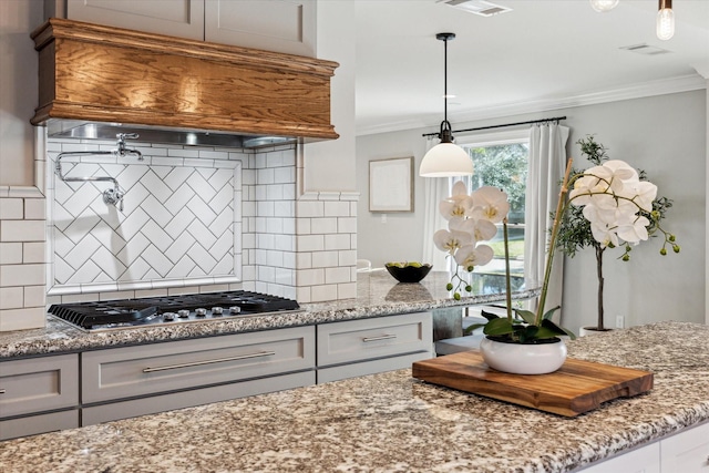 kitchen featuring crown molding, custom exhaust hood, light stone countertops, and stainless steel gas stovetop