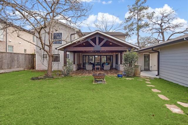 back of property featuring a fire pit and a lawn