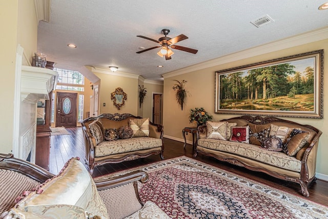 living room with dark hardwood / wood-style flooring, ceiling fan, crown molding, and a textured ceiling