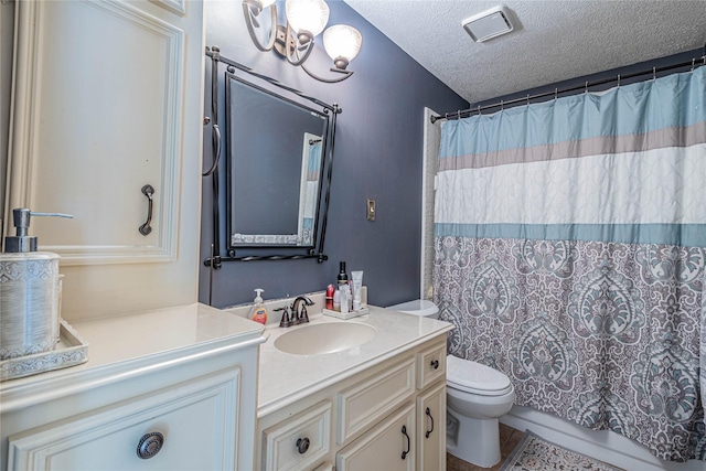 bathroom featuring vanity, a textured ceiling, and toilet