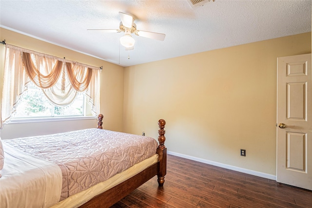 bedroom featuring ceiling fan, dark hardwood / wood-style flooring, and a textured ceiling