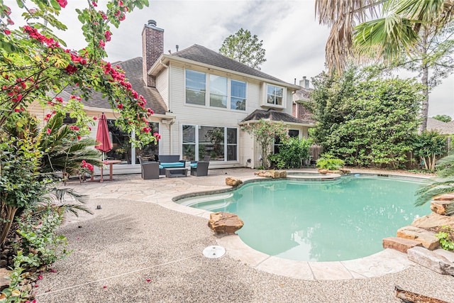 view of swimming pool featuring a hot tub and a patio