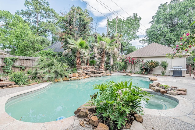 view of pool with an in ground hot tub and area for grilling