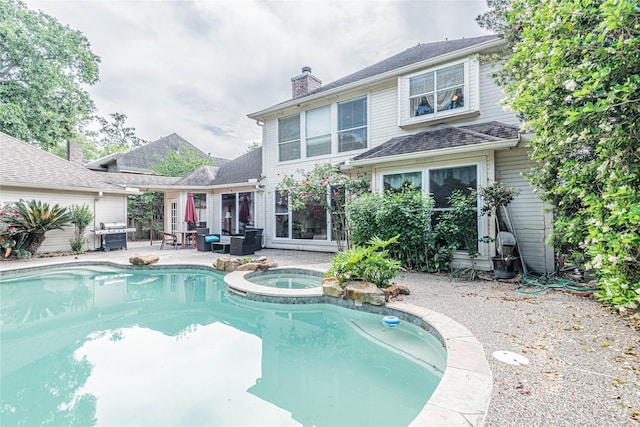 view of pool with an outdoor living space, an in ground hot tub, and a patio area