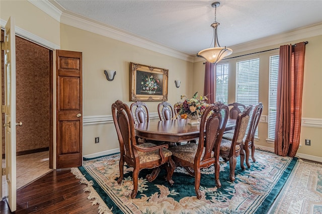 dining space featuring crown molding, wood-type flooring, and a textured ceiling