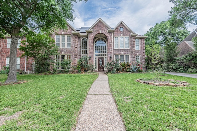 view of front of house with a front yard and solar panels