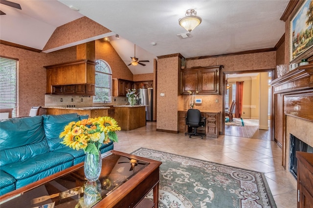 living room featuring light tile patterned flooring, crown molding, built in desk, vaulted ceiling, and ceiling fan