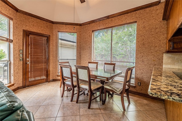 dining room with light tile patterned floors, vaulted ceiling, ornamental molding, and ceiling fan