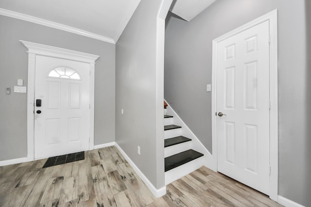 foyer entrance with crown molding and light hardwood / wood-style floors