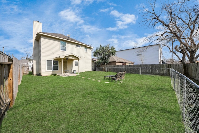 back of house featuring a patio and a yard