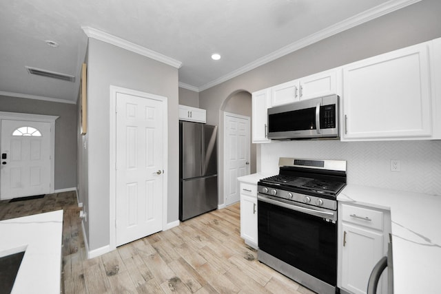 kitchen featuring white cabinetry, crown molding, light hardwood / wood-style flooring, and stainless steel appliances