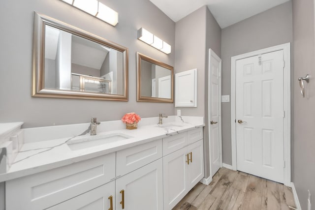 bathroom featuring wood-type flooring, an enclosed shower, and vanity