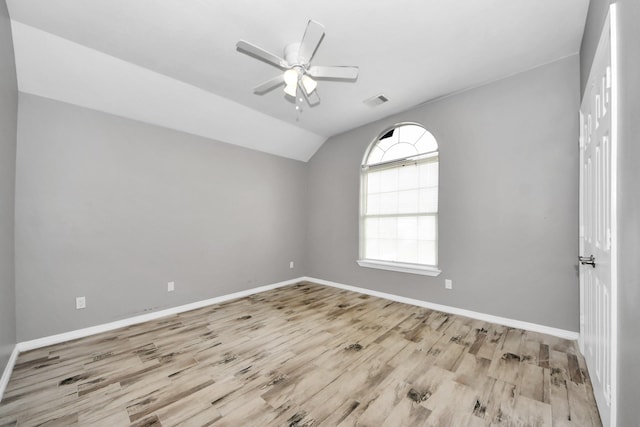 empty room featuring lofted ceiling, light hardwood / wood-style floors, and ceiling fan