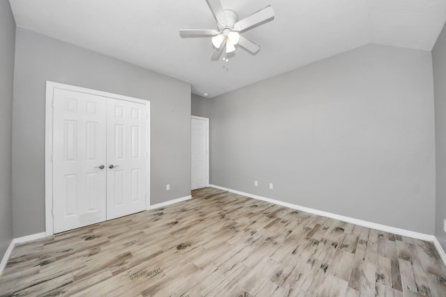 unfurnished bedroom with vaulted ceiling, ceiling fan, light wood-type flooring, and a closet