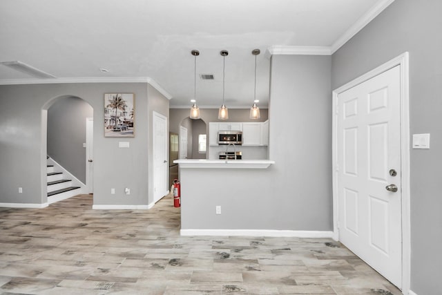 kitchen with white cabinetry, crown molding, hanging light fixtures, light hardwood / wood-style flooring, and kitchen peninsula