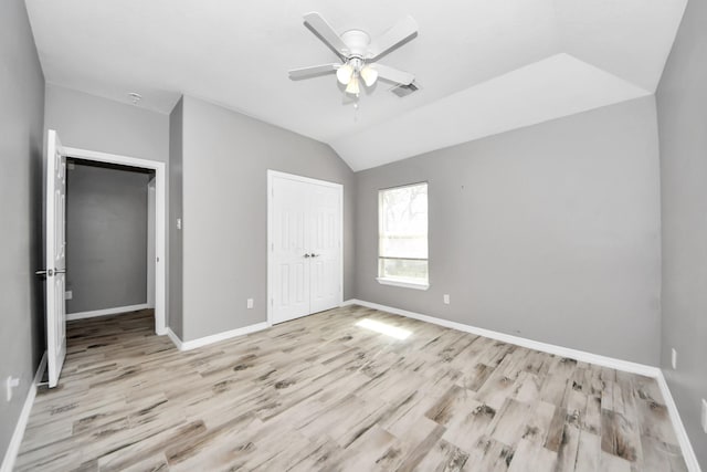 unfurnished bedroom featuring vaulted ceiling, a closet, ceiling fan, and light hardwood / wood-style flooring