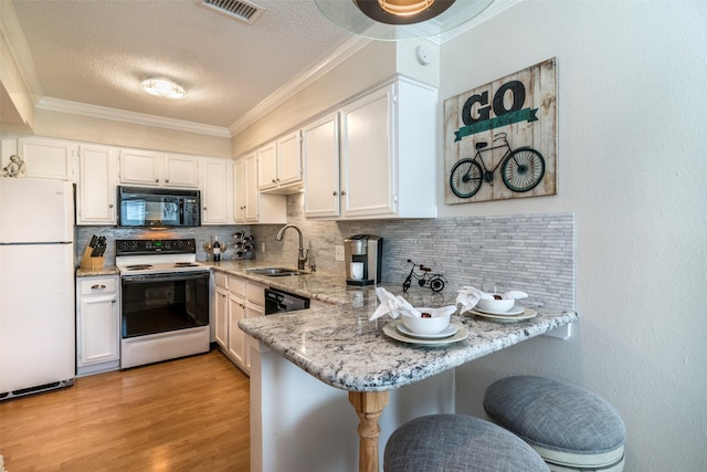 kitchen featuring sink, crown molding, black appliances, light stone countertops, and white cabinets