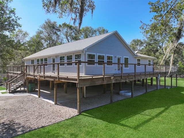 rear view of house featuring a deck and a lawn