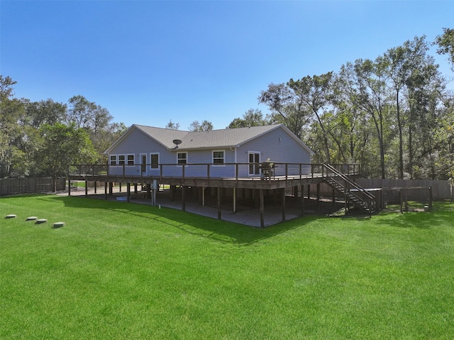 back of property featuring a wooden deck and a lawn