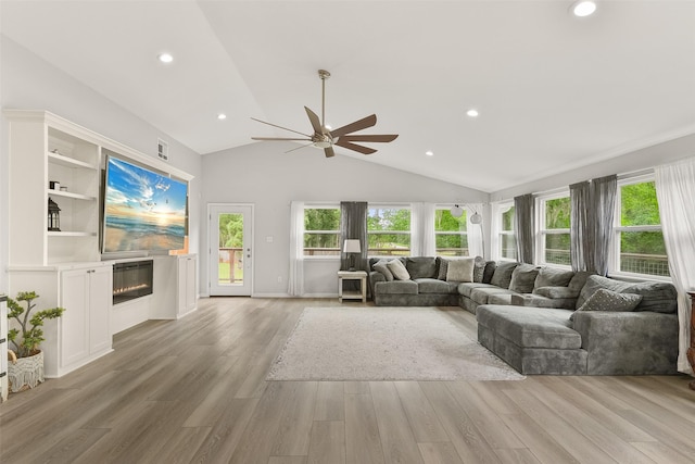 living room with vaulted ceiling, ceiling fan, and light wood-type flooring