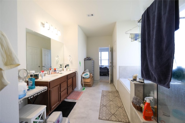 bathroom with vanity and tiled bath