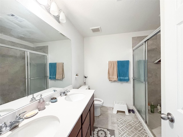 bathroom featuring an enclosed shower, vanity, tile patterned flooring, and toilet