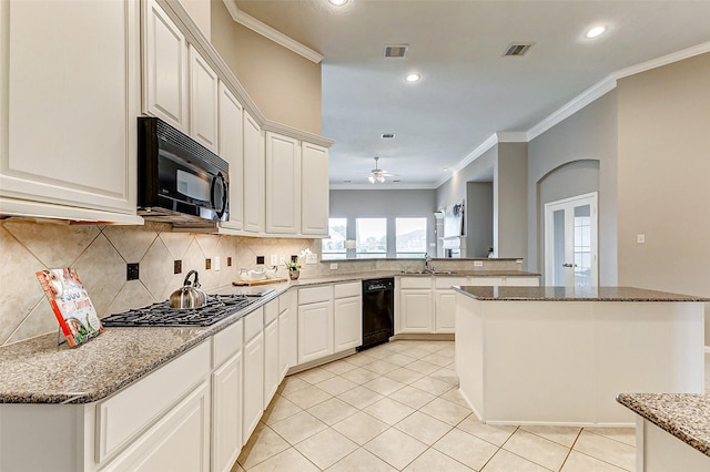 kitchen with black appliances, white cabinetry, backsplash, a center island, and kitchen peninsula