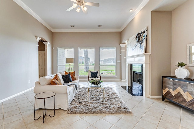 tiled living room featuring crown molding, ceiling fan, and ornate columns