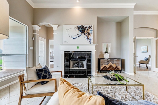 tiled living room featuring a tile fireplace and ornamental molding