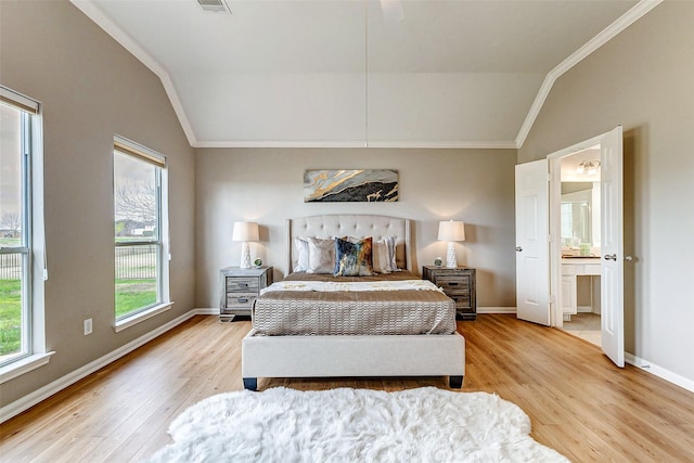 bedroom with light hardwood / wood-style flooring, connected bathroom, crown molding, and vaulted ceiling