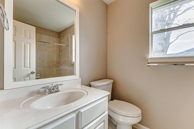 bathroom featuring vanity, toilet, and a tile shower