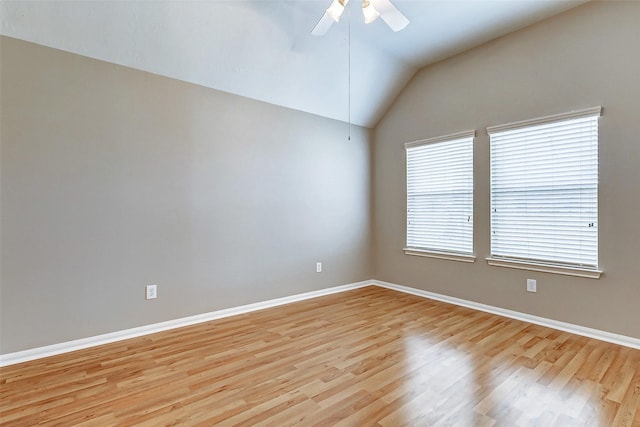 empty room with light hardwood / wood-style flooring, ceiling fan, and vaulted ceiling