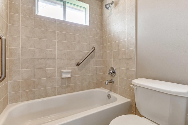 bathroom featuring tiled shower / bath and toilet