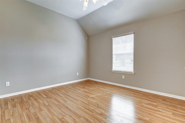 spare room with ceiling fan, lofted ceiling, and light hardwood / wood-style flooring