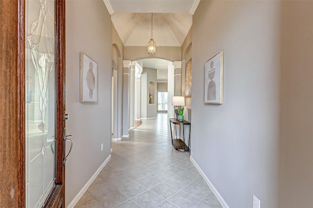 hallway featuring decorative columns, light tile patterned flooring, and crown molding