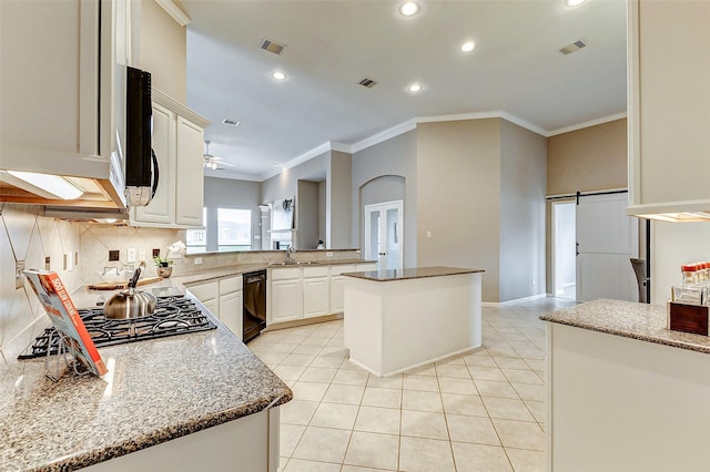 kitchen featuring sink, a center island, black dishwasher, kitchen peninsula, and a barn door