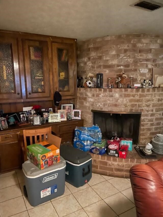 bar with light tile patterned flooring and a brick fireplace