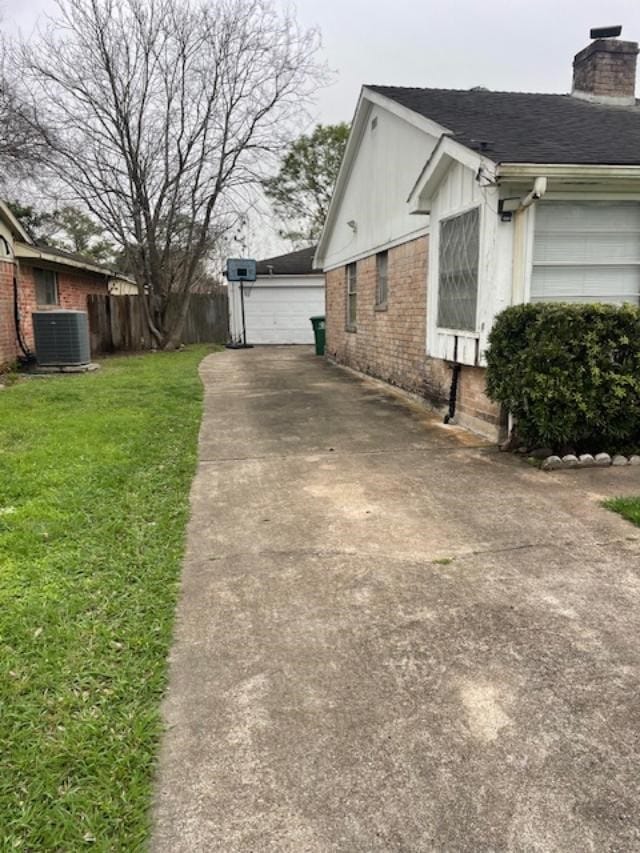 view of side of property featuring cooling unit and a yard