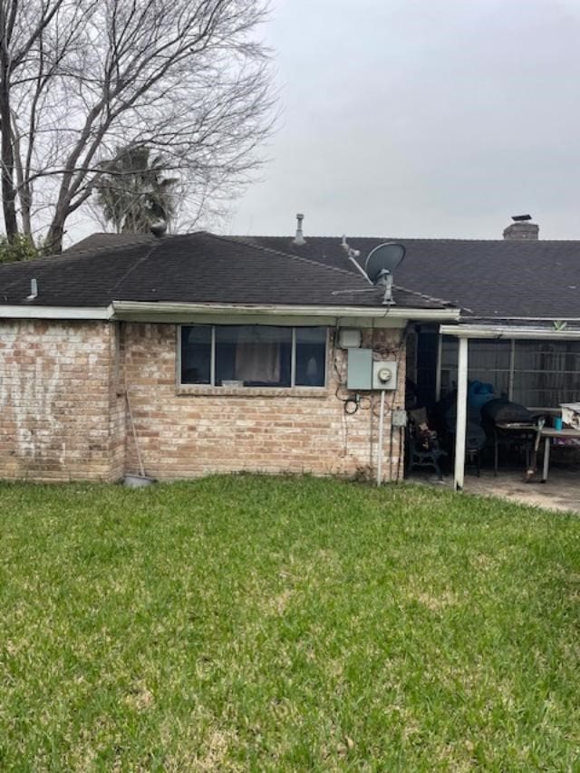 rear view of house featuring a yard