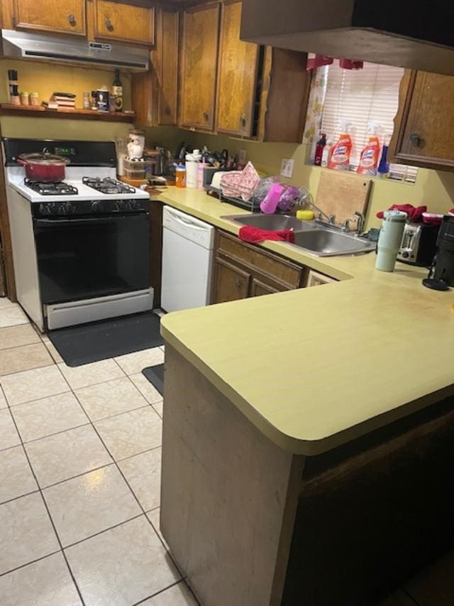 kitchen with range with gas stovetop, dishwasher, sink, light tile patterned floors, and kitchen peninsula