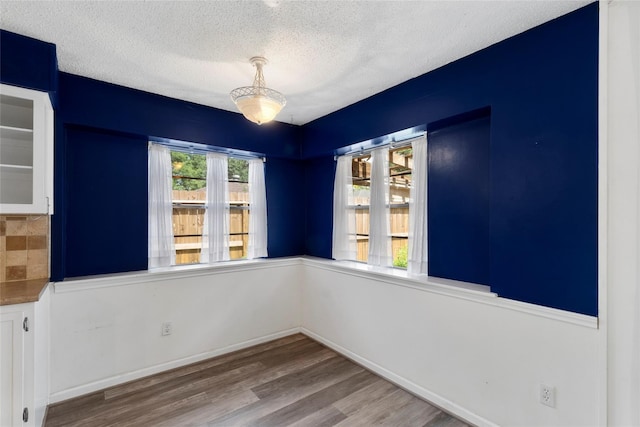 spare room with light hardwood / wood-style flooring and a textured ceiling