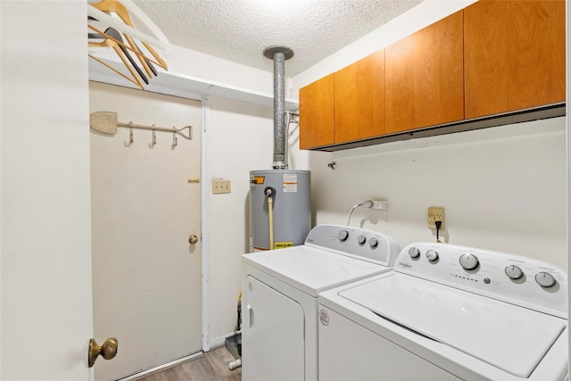 laundry area with washing machine and clothes dryer, gas water heater, cabinets, light hardwood / wood-style flooring, and a textured ceiling