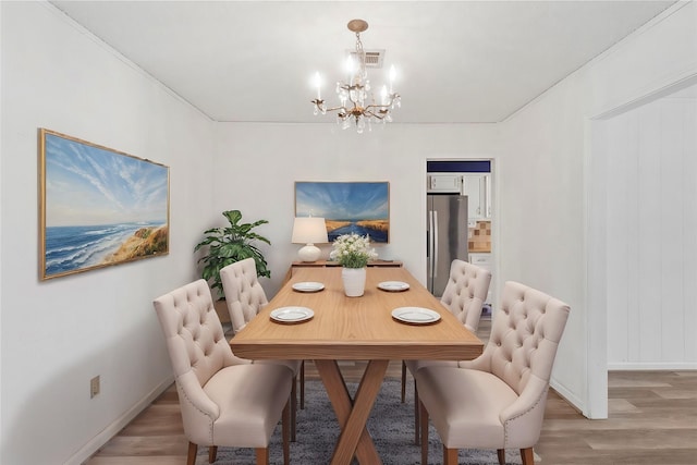 dining room featuring a notable chandelier and light wood-type flooring