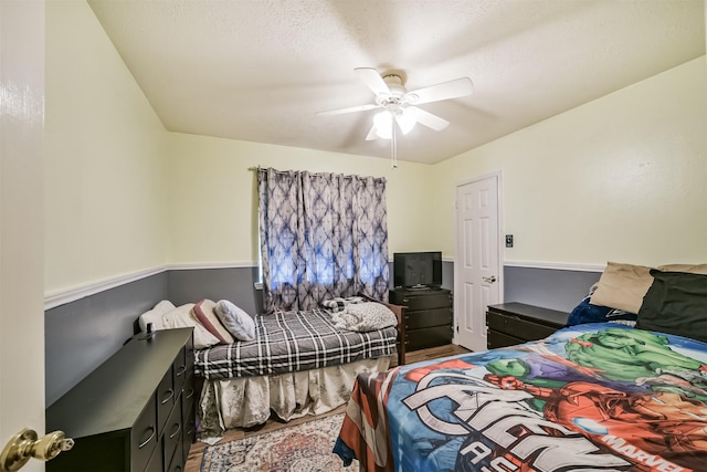 bedroom with a textured ceiling, wood finished floors, and a ceiling fan